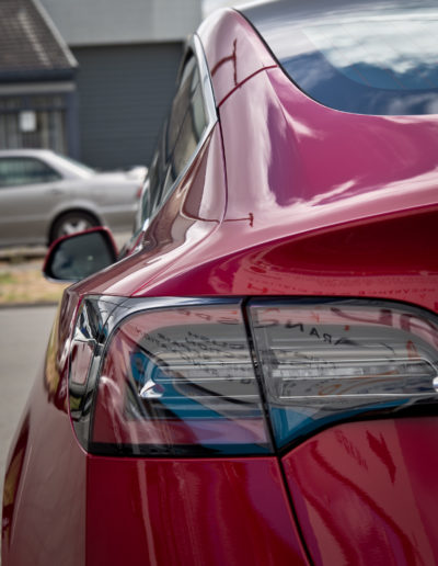 Left rear lights reflecting surroundings