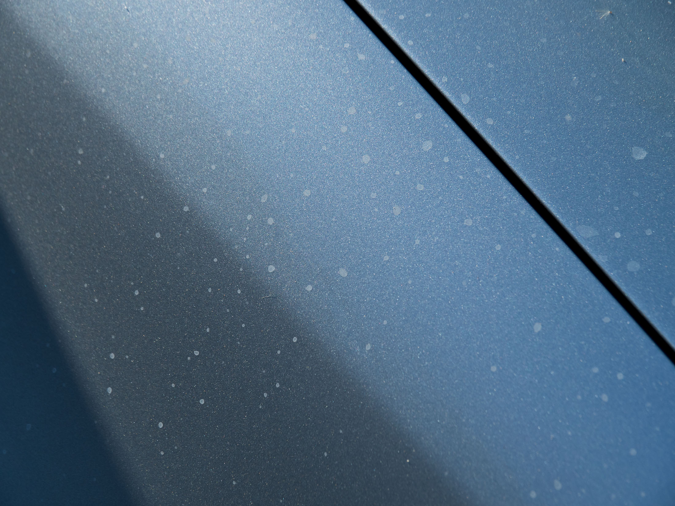 Hard mineral water spots on car paint fender