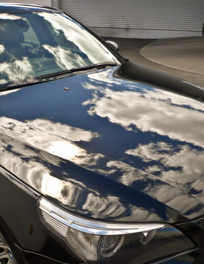 Close up of bonnet with clouds reflecting on surface