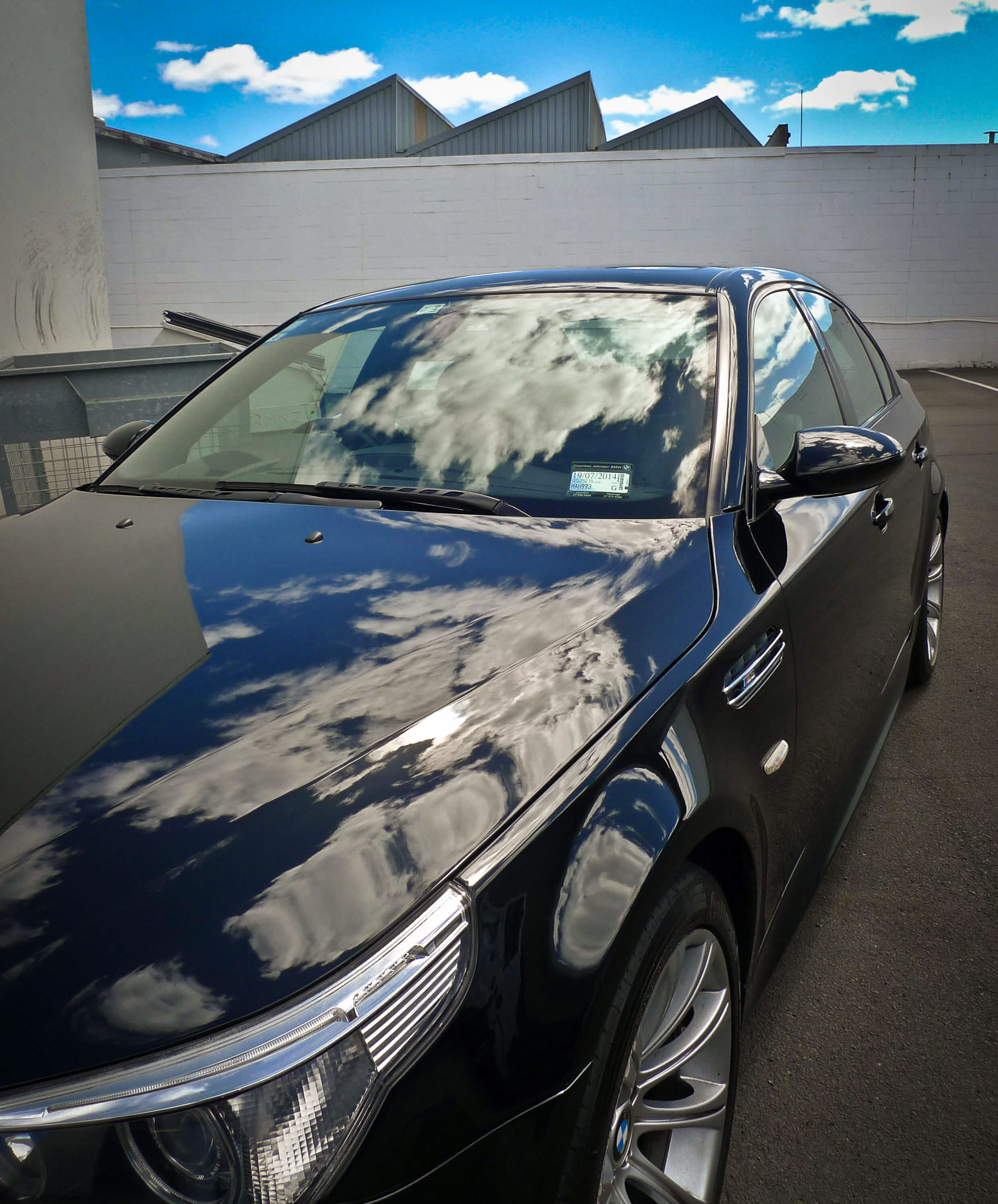 Front left of bonnet with deep black gloss and clouds reflecting on surface after detailing