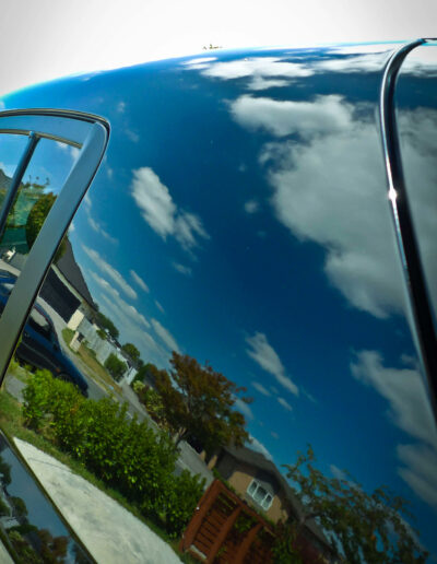 close up of left rear quarter section with clouds and garden reflecting